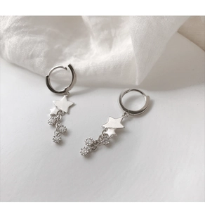 Détail macro de boucles d'oreilles étoile en argent avec glands en zircone