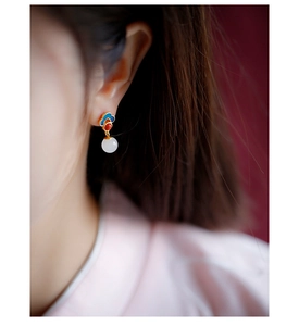 Detailed view of 925 silver Hetian jade earrings with blue enamel ruyi pattern on a model