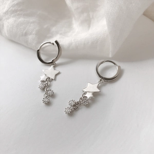 Boucles d'oreilles étoile en argent avec glands étincelants sur tissu blanc