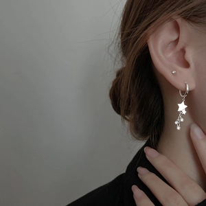 Boucles d'oreilles étoiles en argent sterling avec pompons étincelants portées par modèle