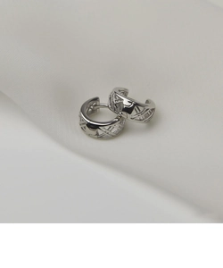 Vue macro des boucles d'oreilles ajourées en argent avec motifs de chiffres romains