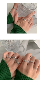 Primer plano de set de anillos vintage plateados con texturas trenzadas y espadas