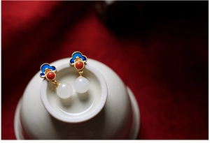 Detailed close-up of 925 silver Hetian jade earrings with blue enamel cloud pattern on porcelain