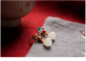Macro shot of 925 silver gold-plated jade earrings with cloisonné enamel cloud pattern
