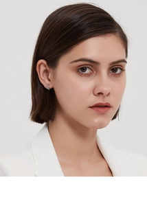 Gros plan de boucles d'oreilles créoles évidées en argent s925 portées par un mannequin