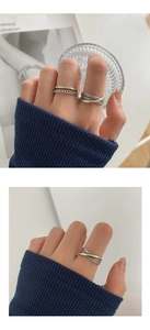 Detalle de anillos plateados vintage con textura de cadena y diseños de estilo minimalista