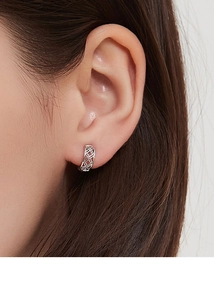 Vue macro de boucles d'oreilles en argent 925 maillage ajouré sur un lobe féminin
