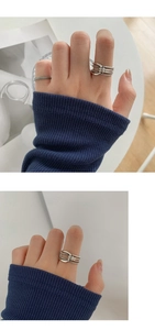 Detalle de un anillo de nudo de plata vintage y banda trenzada en dedo con punto azul
