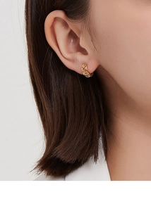 Détail de la texture tressée et ajourée sur boucles d'oreilles créoles dorées