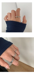 Detalle de un set de anillos de plata vintage con diseño trenzado y banda cruzada