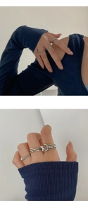 Detalle de anillos de plata vintage con nudos y trenzados para un estilo de capas