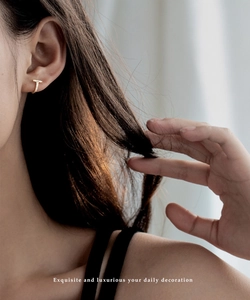 Boucle d'oreille en T dorée avec cristaux portée de profil par un mannequin
