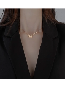 Nahaufnahme einer eleganten Gold-Schmetterlingskette mit Zirkonia an einem Modell