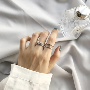 Silver Roman numeral and 520 wide band stackable ring set on female finger