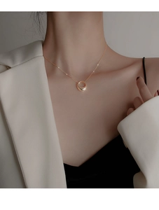 Detailed view of elegant gold geometric circle pendant necklace on a female neck