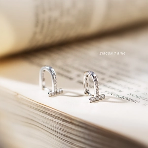 Vue macro des boucles d'oreilles T en argent avec zircon et poinçon S925