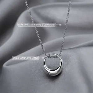 Minimalist sterling silver geometric circle pendant necklace on grey silk background
