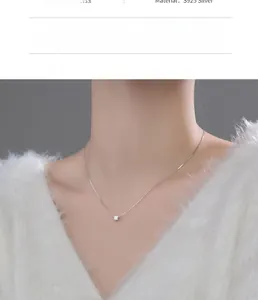 Close-up of minimalist S925 silver cube pendant on model with a soft background