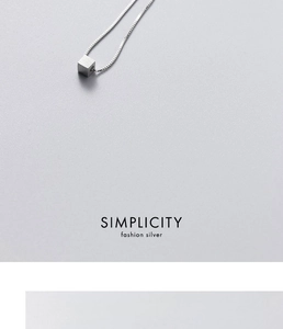 Detailed macro view of brushed geometric cube pendant on a silver box chain necklace