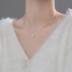 Minimalist S925 sterling silver cube necklace worn on neck with a white knit sweater