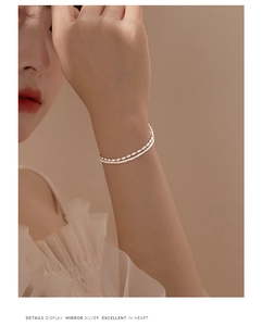Close-up of a double-layer silver beaded bracelet showing delicate texture and detail
