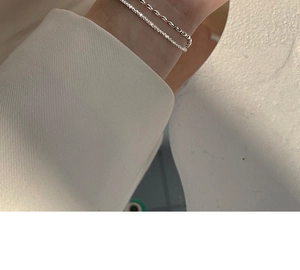 Double-layer silver chain bracelet with polished oval beads on a female model wrist