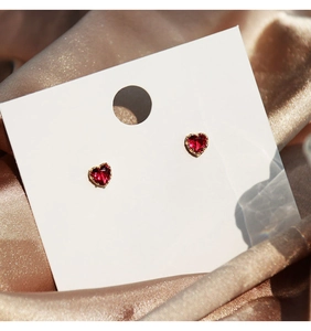 Exquisite pair of gold-plated red heart-shaped zircon earrings on silk fabric