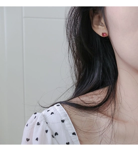 Close-up of red heart-shaped zircon stud earring worn by model in a sweet elegant style