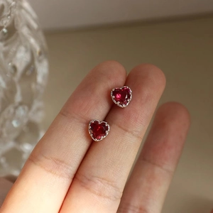 S925 Sterling Silver heart stud earrings with red cubic zirconia held by hand