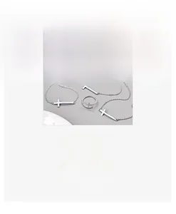 Dettaglio di un set di collane con croce in argento e un anello aperto minimalista