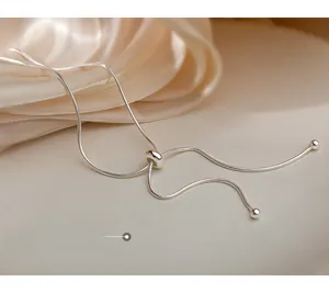 Detail of adjustable silver snake chain with slider bead on elegant silk background