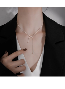 Close-up of adjustable silver snake bone necklace with tassel slide knot on model