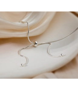 Macro shot of adjustable silver snake chain necklace showing sliding buckle and silk texture