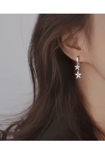 Gros plan de boucles d'oreilles fleur en argent avec zircon blanc sur modèle