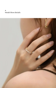Detail shot of a gold ring featuring square-cut zircons worn by a fashion model