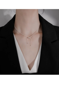 Detail of adjustable snake chain necklace with elegant silver tassel knot and bead charm