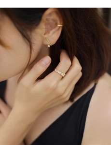 Detailed view of square zircon ring and ear cuff set in elegant gold plated finish