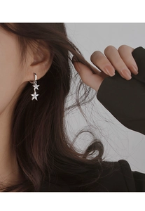 Gros plan sur d'élégantes boucles d'oreilles fleur avec zircons sur un mannequin femme