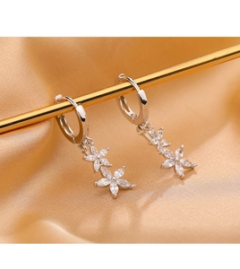 Gros plan de boucles d'oreilles en argent avec fleurs en zircon sur satin