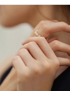 Detailed view of square-cut diamonds on a minimalist gold-plated silver ring worn on finger