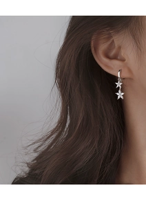 Gros plan de boucles d'oreilles fleurs en argent avec zircon blanc sur un mannequin