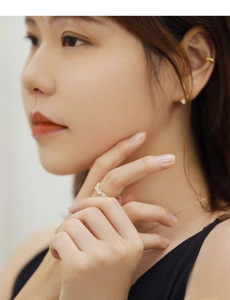 Close-up of gold ring with rectangular zircons on model's finger in elegant setting