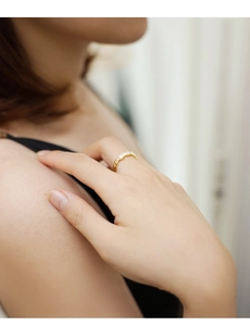 Close-up of elegant 18K gold ring with baguette cut stones on a woman's finger
