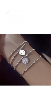 Detail of S925 sterling silver beaded bracelet featuring Lucky pendant and pavé ball charm