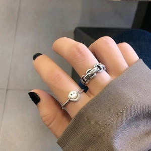 Close-up of vintage chain rings with keep smiling engraving and retro silver finish