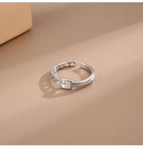 Détail macro d'une bague ceinture ajustable avec zircons incrustés sur argent poli