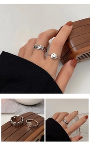 Detailed shot of retro chain ring with keep smils engraving and smiley face pendant