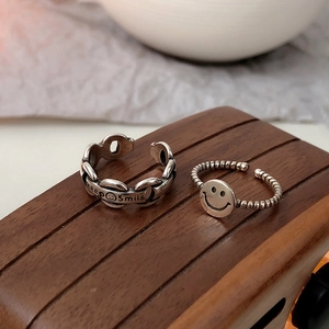 Detail of vintage silver adjustable rings featuring chain design and Keep Smiles engraving
