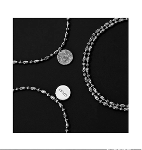 Macro shot of silver beaded bracelet featuring a lucky pendant and star matte texture