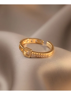 Détail macro d'une bague boucle de ceinture dorée avec cristaux sur fond de soie douce